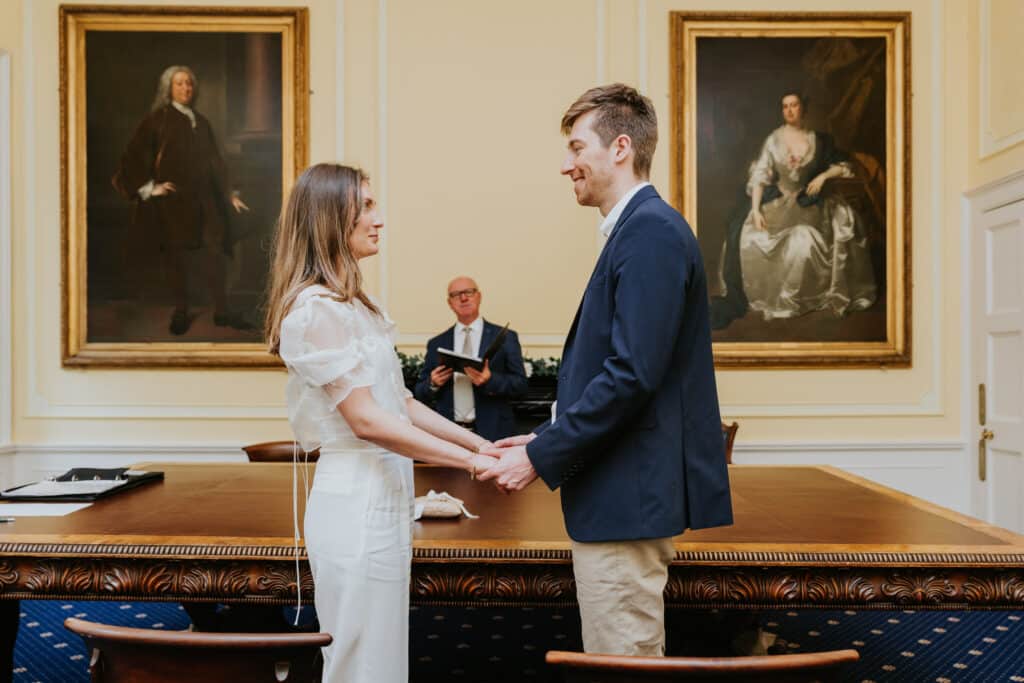 Intimate wedding photography Bristol registry office 13 Couple hold hands and say their vows in the Bristol Room at the registry office