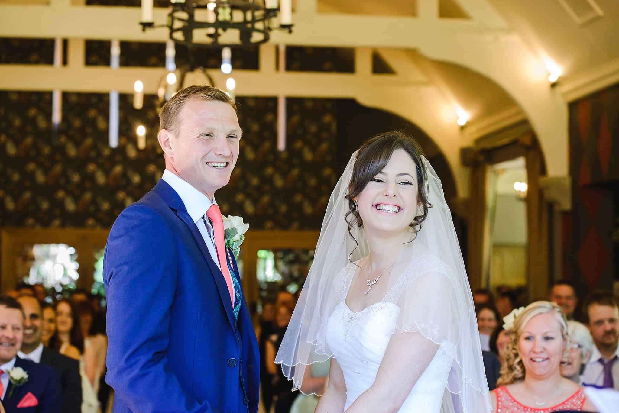 Bride and groom smiling during their wedding ceremony at the Hare and hounds Tetbury