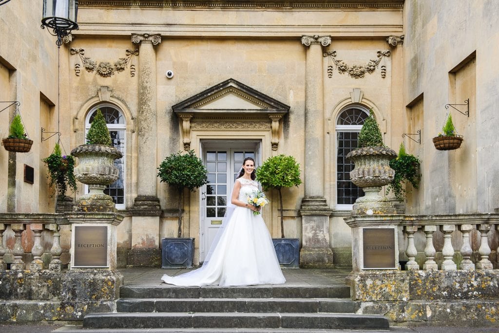 Bride stood on the steps in her wedding dress at Bailbook House