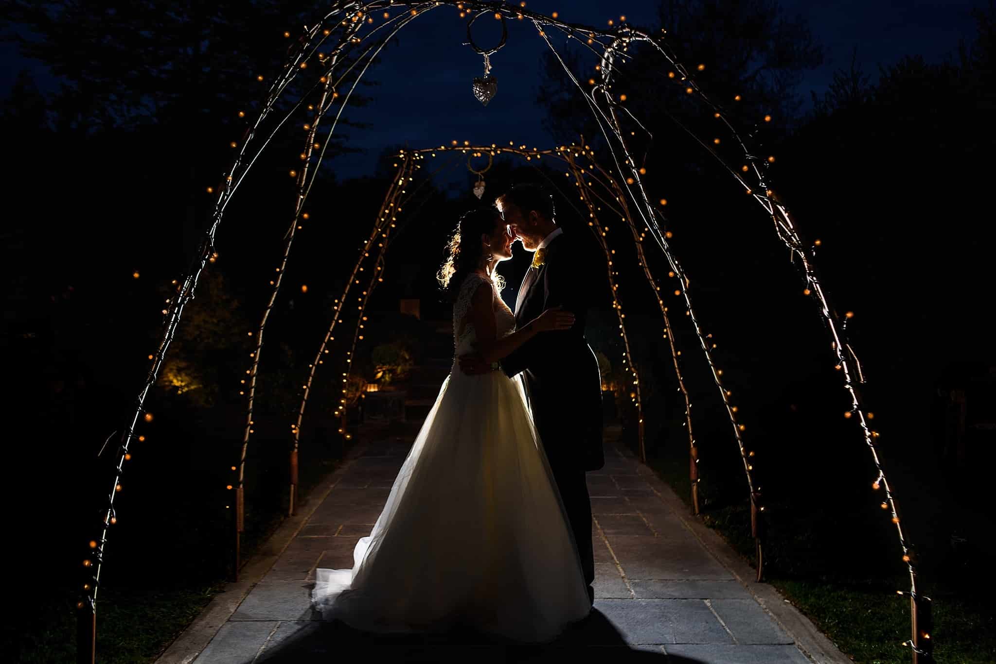 A night shot of bride and groom being back lit outside Wick Farm