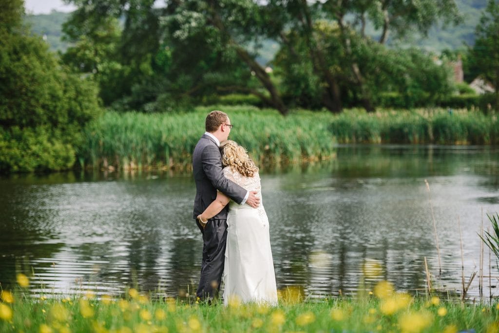 Couple look out on to the lake near their Nailsea Tithe barn wedding