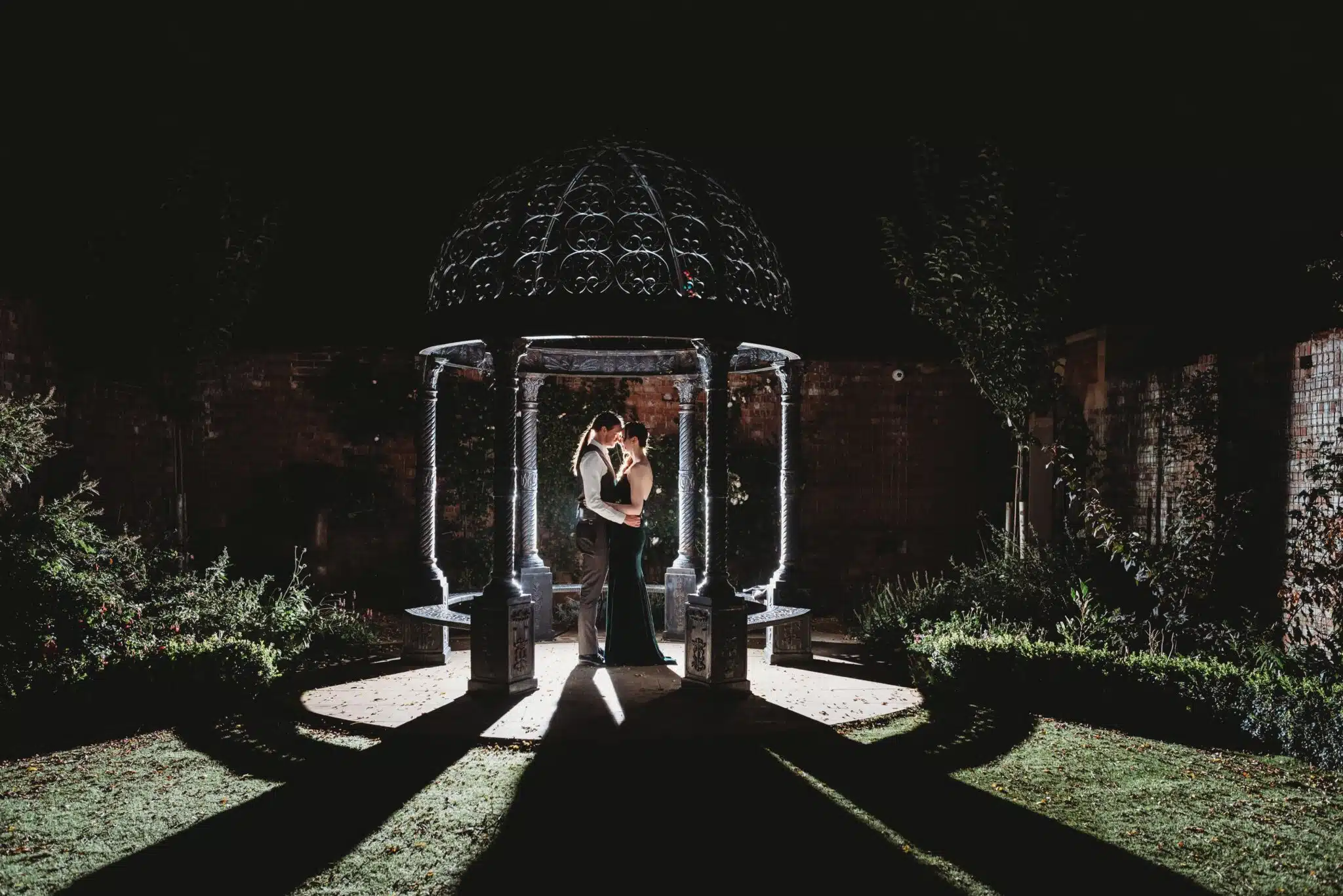 Night portrait of couple being back lit in the ground of Kings Weston House
