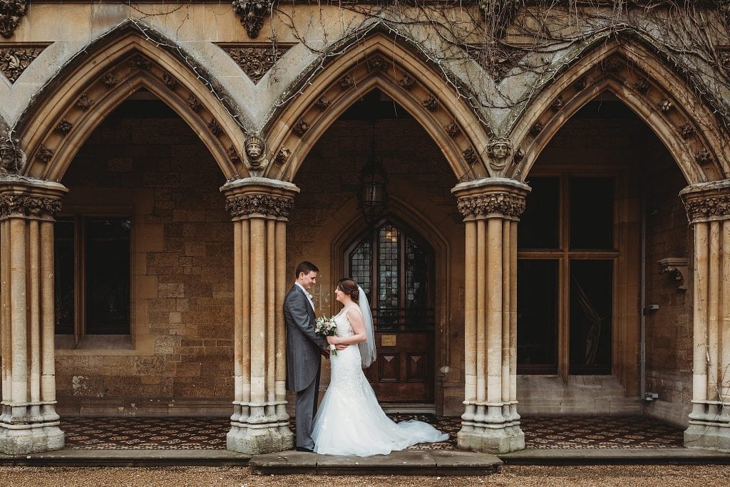 Manor by the lake wedding photographer - couple stood in the archways