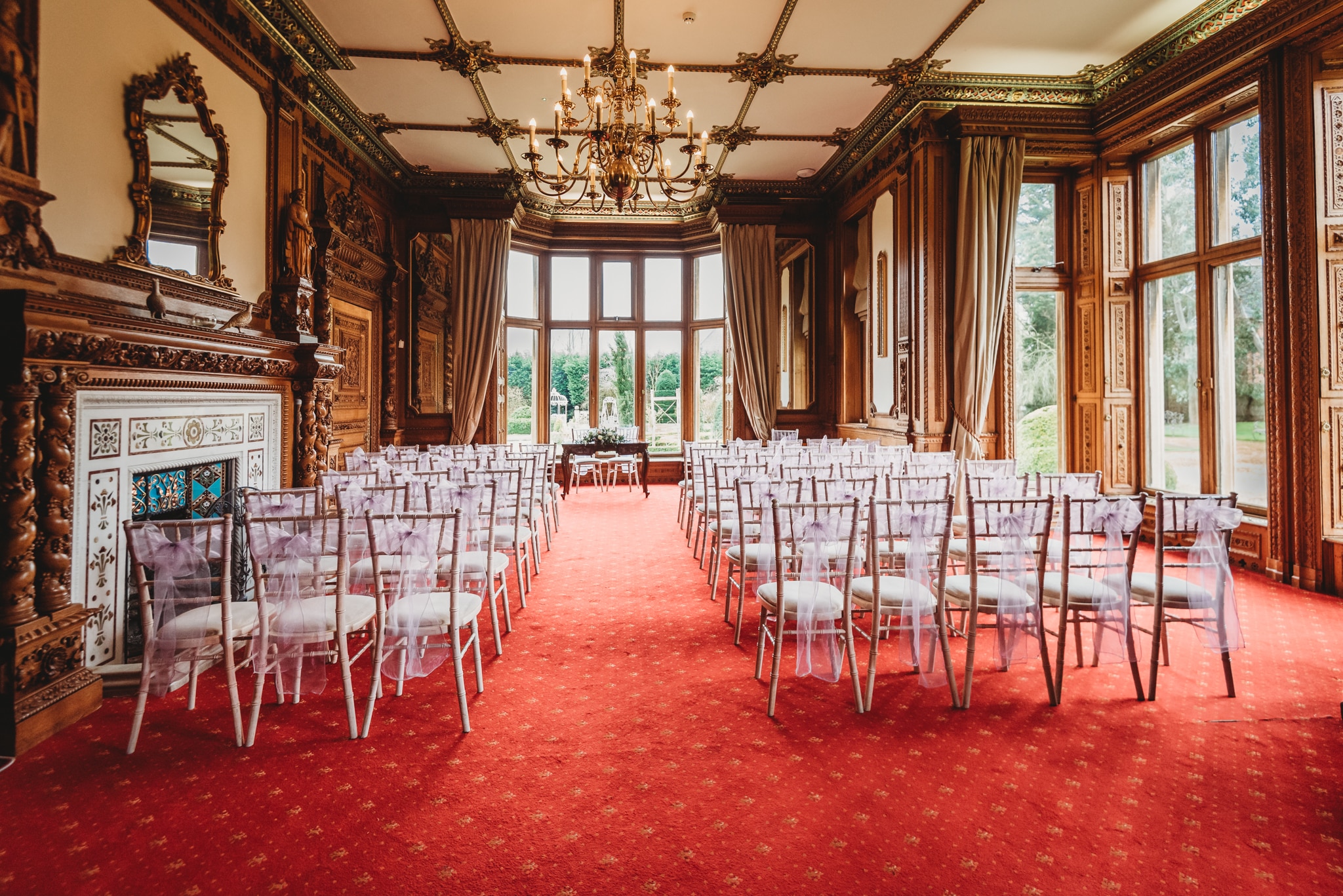 Maximillian wedding ceremony room with red carpet, dark wood and chandelier
