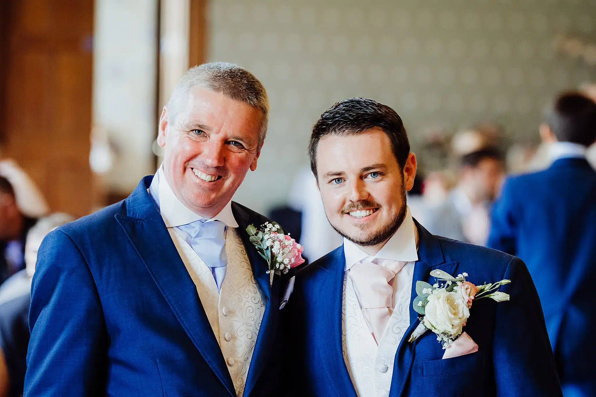 A smiling groom and his best man at a wedding ceremony at Gregnog Hall