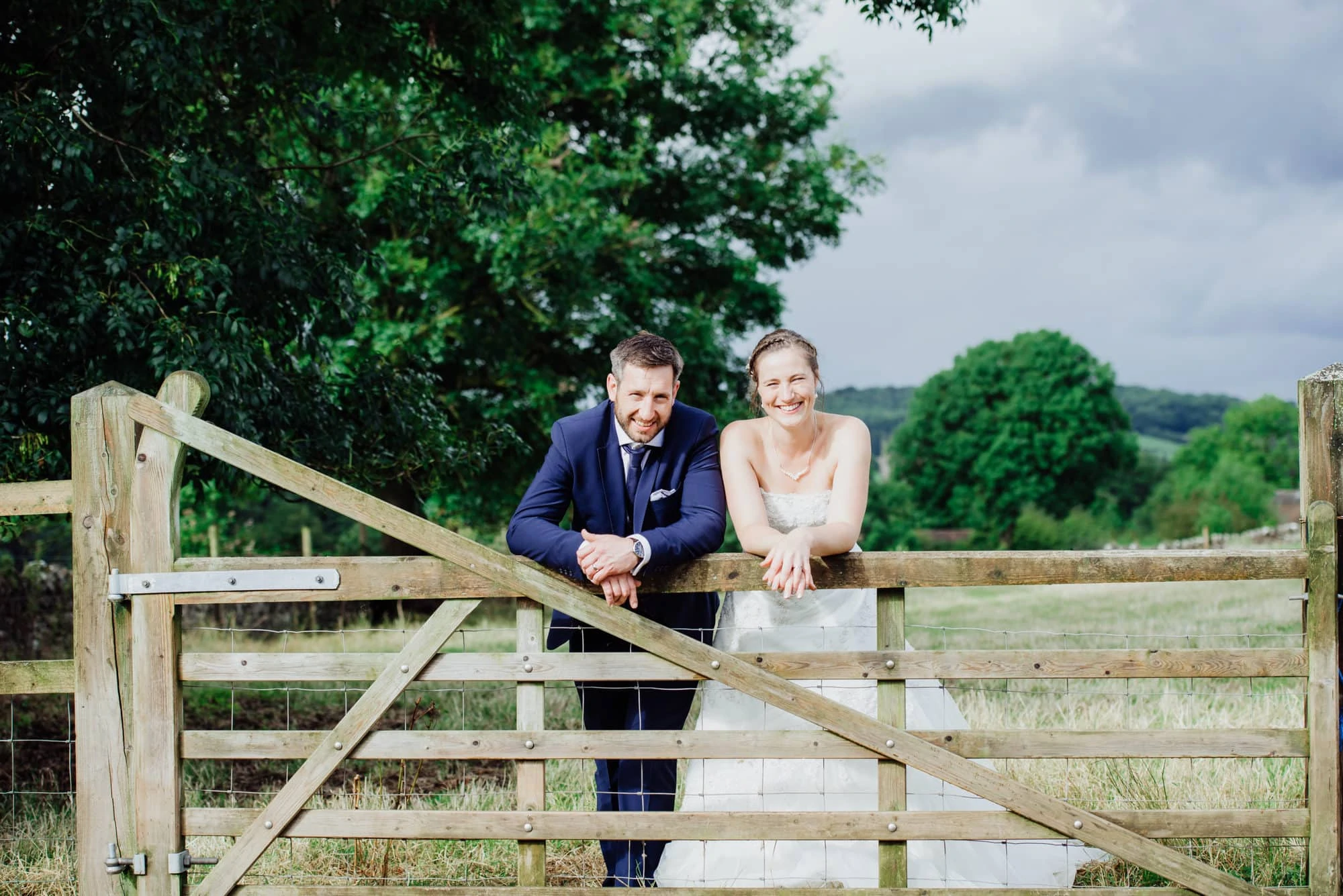 couple stood over fence in a field in Somerset
