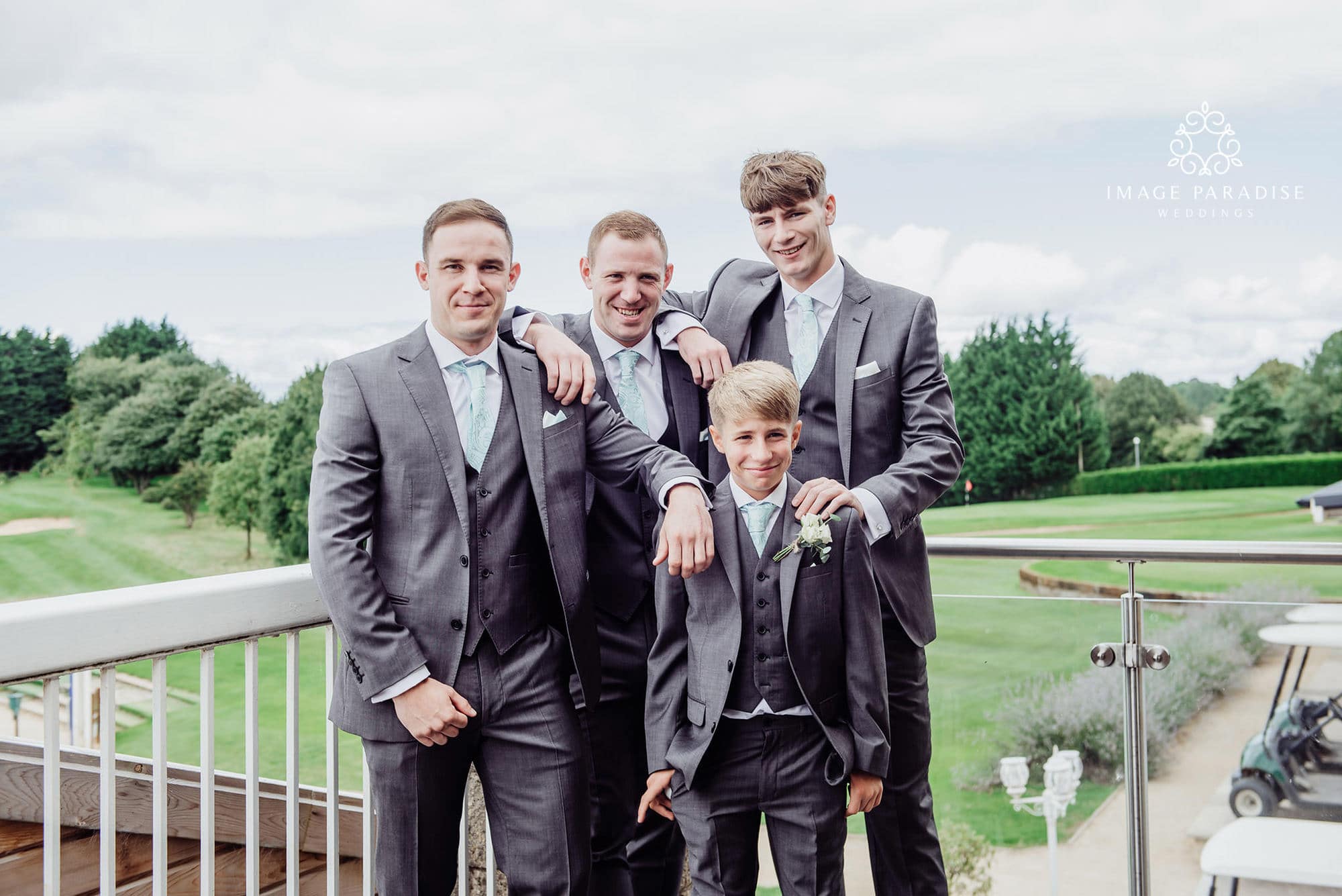 Cotswolds Hotel & Spa wedding photography | Chipping Norton photographer 13 groomsmen stood on the balcony with the golf course in the backdround of the Cotswolds hotel and spa golf course wedding venue