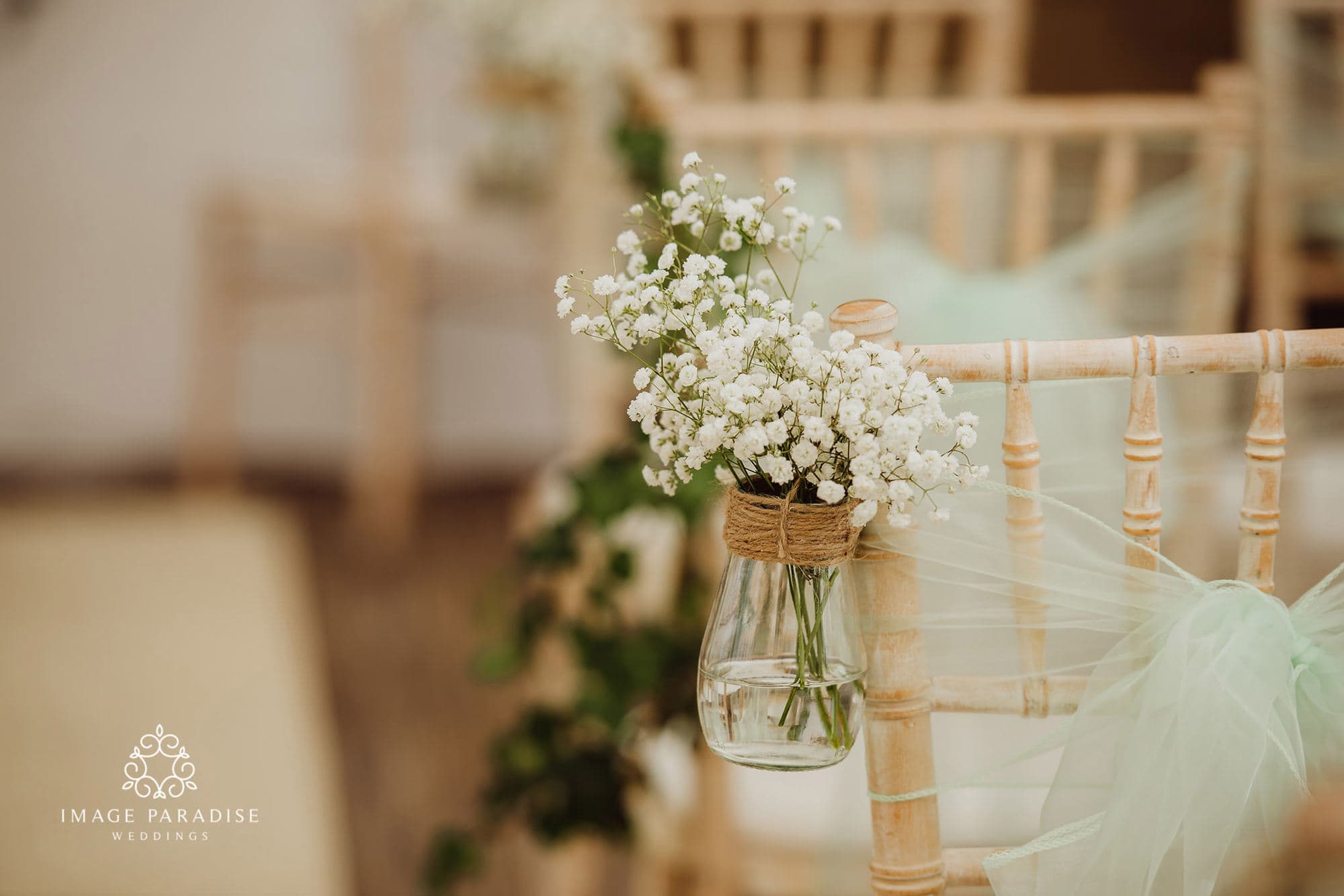 Cotswolds Hotel & Spa wedding photography | Chipping Norton photographer 5 close up of flowers on the end of a chair at a wedding ceremony at Cotswolds hotel and spa wedding venue