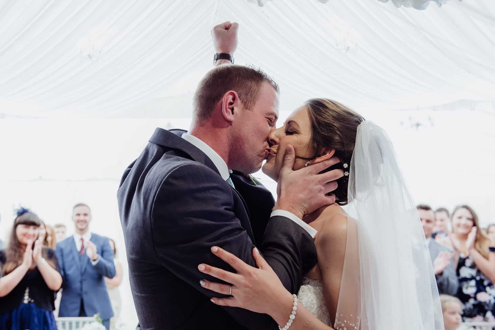 Cotswolds Hotel & Spa wedding photography | Chipping Norton photographer 18 Wedding kiss with groom punching the air at the Cotswolds hotel wedding ceremony
