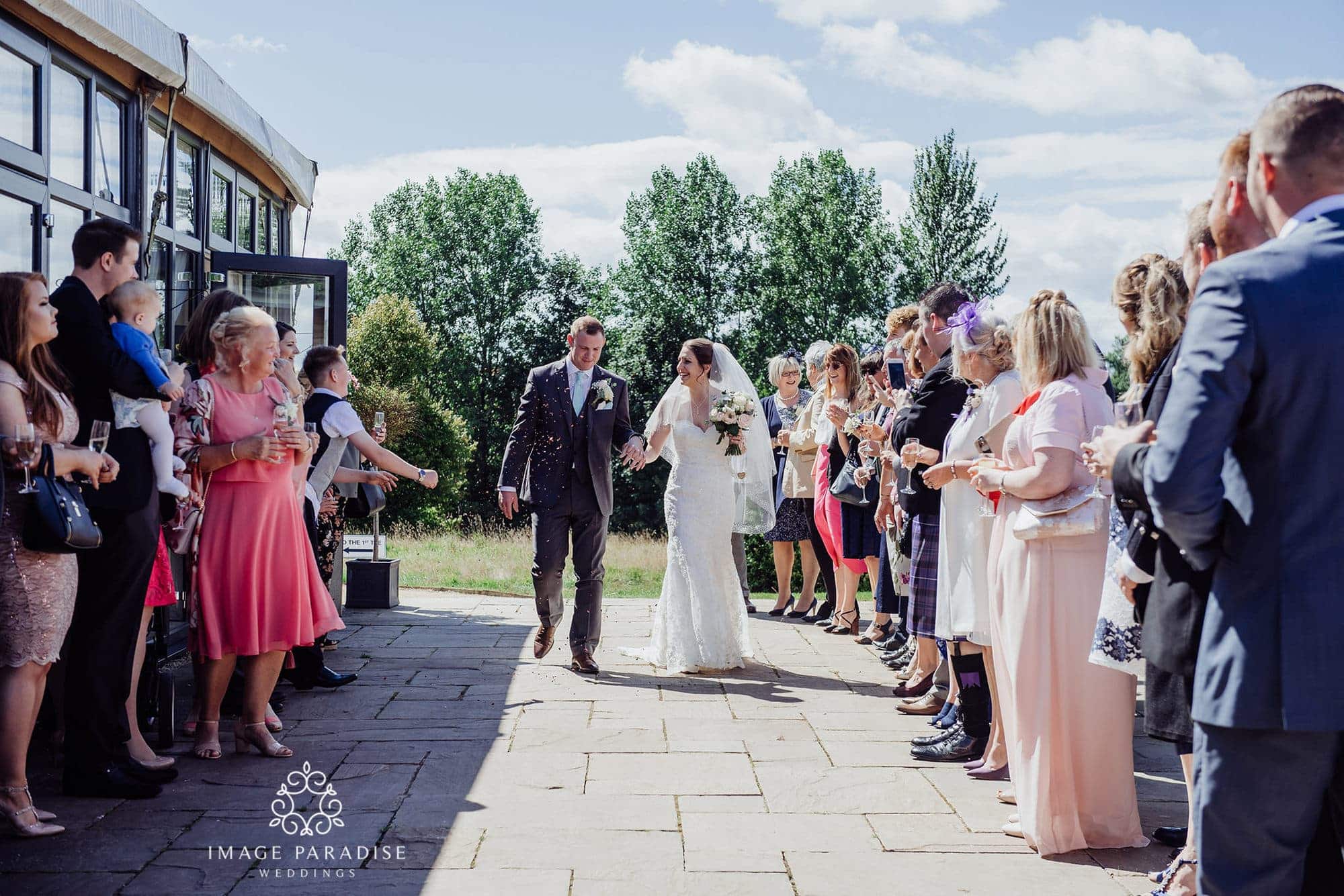 Cotswolds Hotel & Spa wedding photography | Chipping Norton photographer 20 confetti being thrown by guests in the garden of Cotswolds hotel and spa