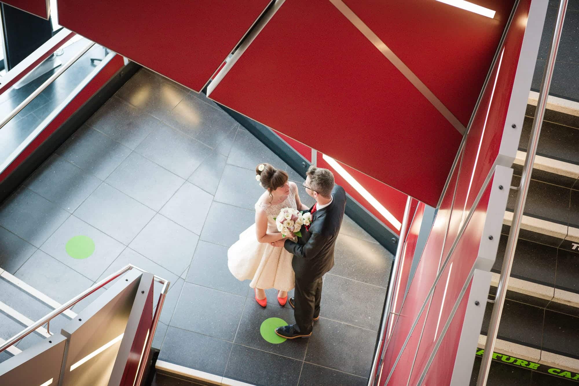 A bride and groom embrace in the middle of the staircase at the M-shed wedding venue Bristol