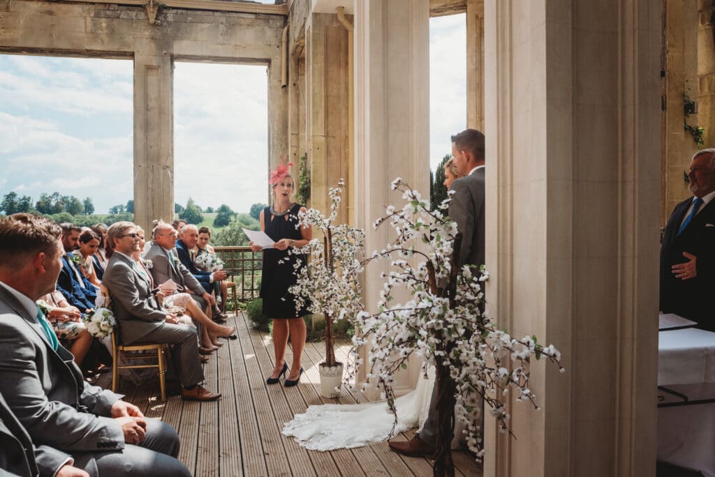 Guest giving a reading during an outdoor ceremony at Orchardleigh House wedding