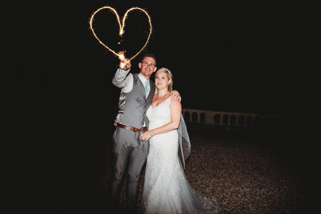 couple wave a sparkler heart at orchardleigh wedding venue