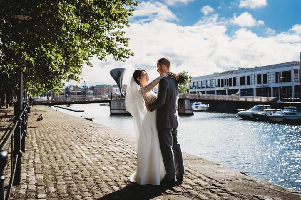 Bristol wedding photographer photo of bride and groom facing each other with Bristol harbour in the background