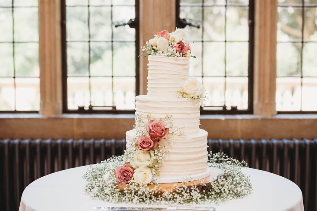 Wedding cake in front of the windows at Coombe Lodge