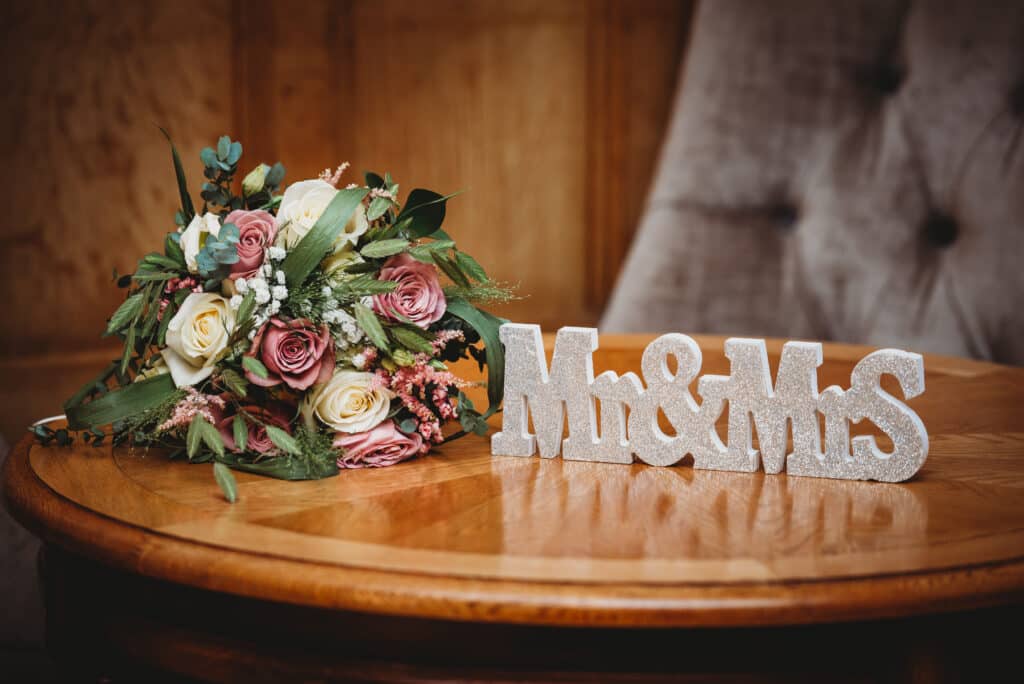 Bride flowers with mr and mrs sign on a table at Coombe Lodge